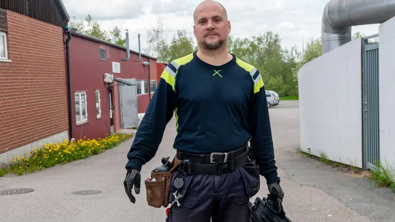Man med verktygsbälte och väska redo för termografering el. i industriområde.