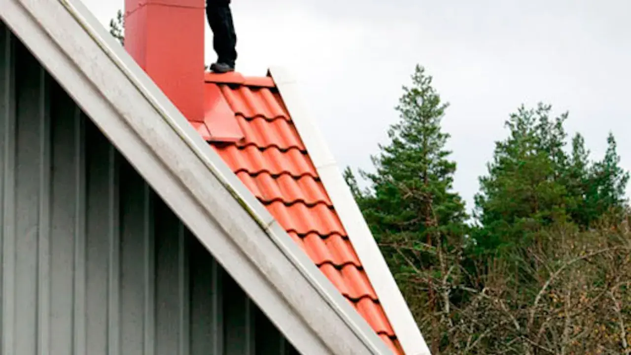 Person på taket vid skorstenen, en del av en sotarutbildning.