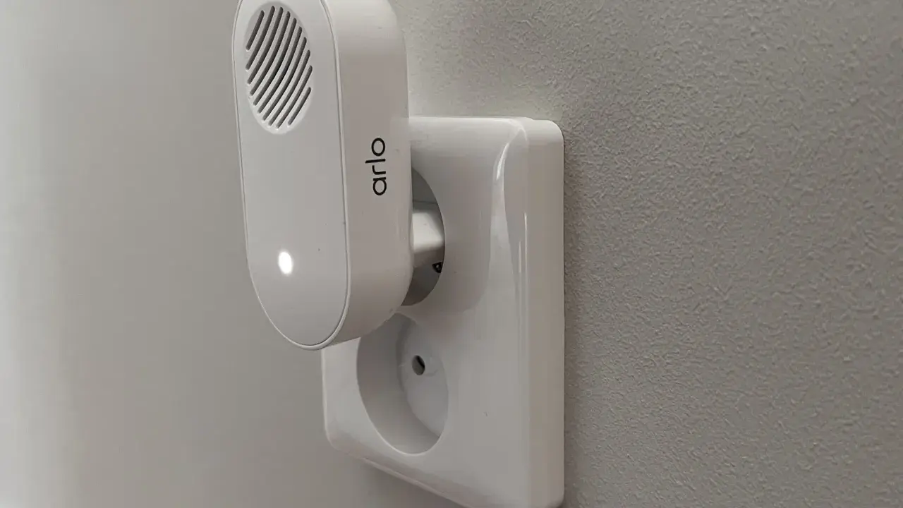 Arlo doorbell-installation: en vit Arlo-enhet med en lysande prick är ansluten till ett vägguttag.