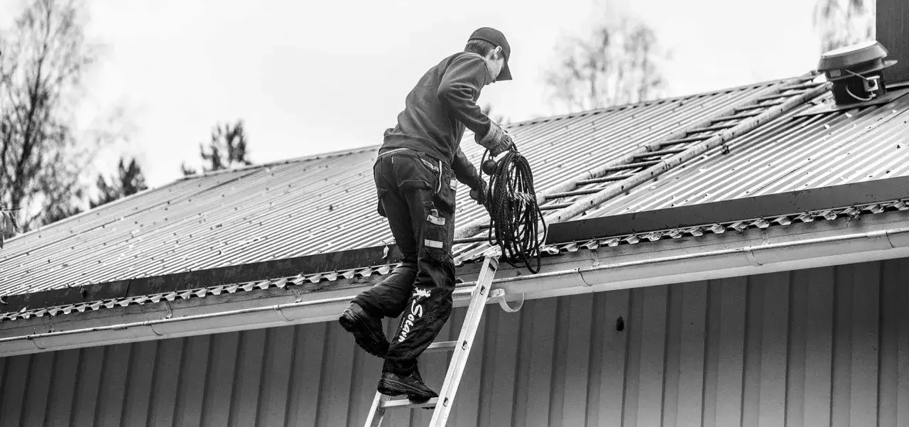 Sotare klättrar på taket med en rulle rep. Även om man inte eldar, måste man sota för att underhålla skorstenen.