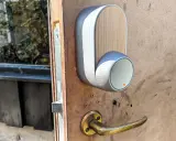 En modern Yale Doorman låser inte. Dörrhandtaget är av mässing, och enheten har en trädetalj.