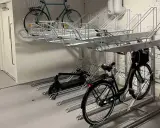 Här kan du ladda elcykeln på jobbet. Parkeringsställ för cyklar och elsparkcyklar i en lokal.