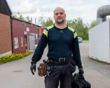 Man med verktygsbälte och väska redo för termografering el. i industriområde.