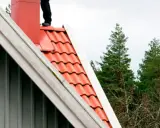 Person på taket vid skorstenen, en del av en sotarutbildning.