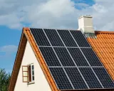 Solceller på ett tegeltak. En öppen fönsterlucka syns på husets gavel. Vissa oroar sig för solceller brandrisk.