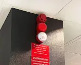 Rött och vitt larmdon brandlarm med textskylt. En varningssignal för utrymning.