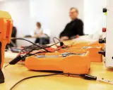 Orange multimeters och en vit apparat på ett bord, redo för pyroteknik utbildning.
