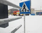 Snöig arbetsplats med brandbil och en person i varselväst. En övergångsställe-skylt står framför. Kanske en leveransbesiktning brandlarm pågår.