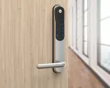 Modernt Yale-dörrlås med kodtangentbord och handtag på en trä dörr.