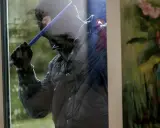 Tjuv försöker bryta sig in genom ett fönster, kanske för att ta bort en Verisure huvudenhet.