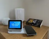 En smartklocka visar 15:07, en mobil ligger redo att ladda mobilen på natten bredvid en bok.
