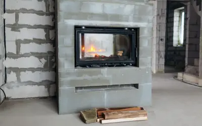 En nyinstallerad kamin med eld i, omgiven av byggmaterial. Snart blir det varmt och mysigt!