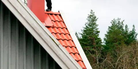 Person på taket vid skorstenen, en del av en sotarutbildning.