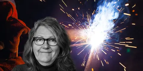Kvinna med glasögon ler framför en bakgrund av gnistor från heta arbeten. En svetsare i skyddskläder syns till vänster.