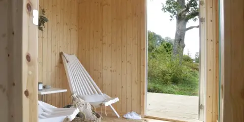 Mysig bastu med vedkamin, perfekt för avkoppling. Tänk på brandskyddsregler vedeldad bastu för säker njutning.