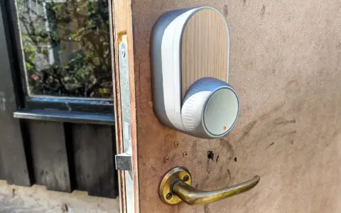 En modern Yale Doorman låser inte. Dörrhandtaget är av mässing, och enheten har en trädetalj.