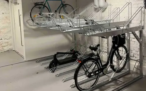 Här kan du ladda elcykeln på jobbet. Parkeringsställ för cyklar och elsparkcyklar i en lokal.