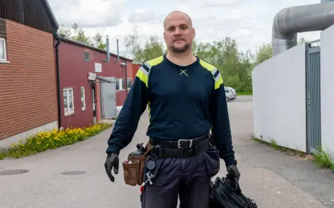 Man med verktygsbälte och väska redo för termografering el. i industriområde.