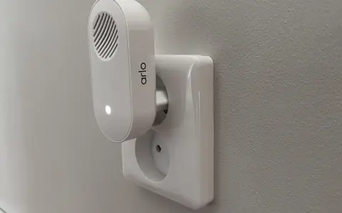Arlo doorbell-installation: en vit Arlo-enhet med en lysande prick är ansluten till ett vägguttag.