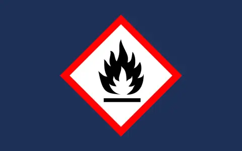 Varning för brandfarliga ämnen, som bensin. Symbolen visar en flamma över en linje, vilket indikerar låg flampunkt.