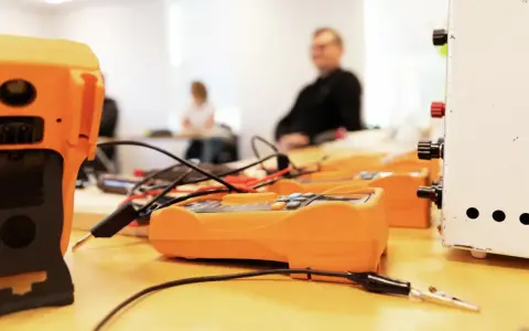 Orange multimeters och en vit apparat på ett bord, redo för pyroteknik utbildning.