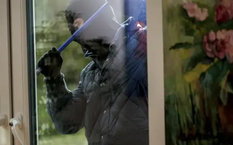 Tjuv försöker bryta sig in genom ett fönster, kanske för att ta bort en Verisure huvudenhet.
