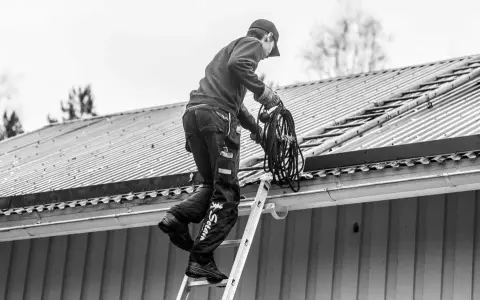 Sotare klättrar på taket med en rulle rep. Även om man inte eldar, måste man sota för att underhålla skorstenen.