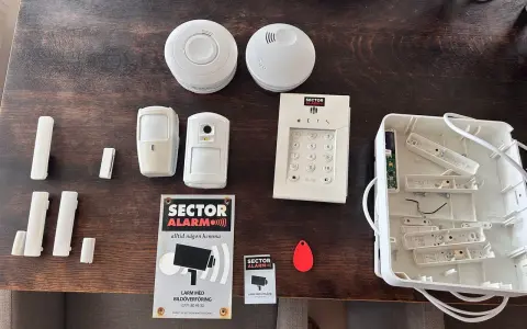 Säkerhetssystem från Sector Alarm, inklusive larmpanel, rörelsedetektorer, dörrsensorer och en tom larmcentral. Perfekt för en trygg home assistant.