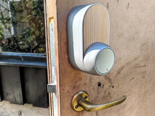 En modern Yale Doorman låser inte. Dörrhandtaget är av mässing, och enheten har en trädetalj.