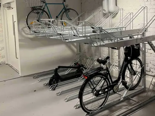 Här kan du ladda elcykeln på jobbet. Parkeringsställ för cyklar och elsparkcyklar i en lokal.
