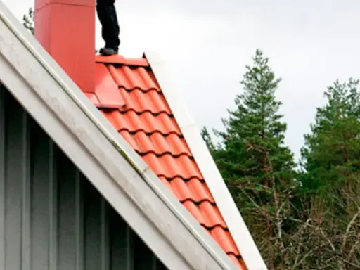 Person på taket vid skorstenen, en del av en sotarutbildning.