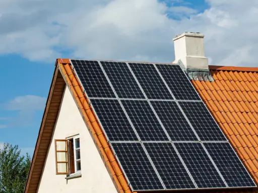 Solceller på ett tegeltak. En öppen fönsterlucka syns på husets gavel. Vissa oroar sig för solceller brandrisk.