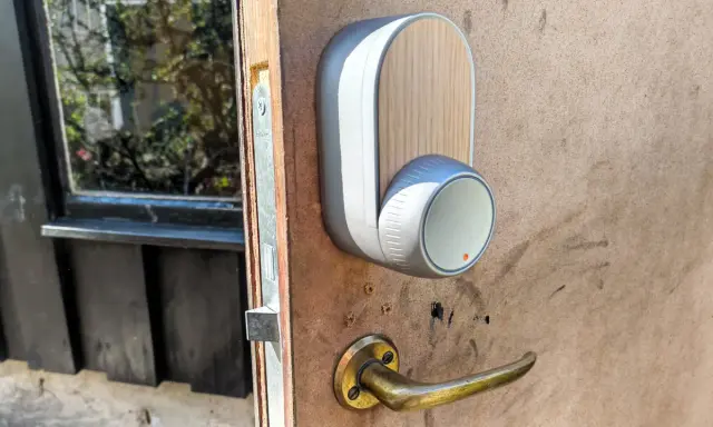 En modern Yale Doorman låser inte. Dörrhandtaget är av mässing, och enheten har en trädetalj.