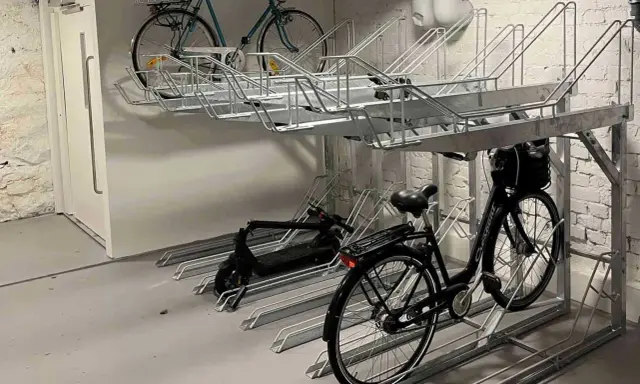 Här kan du ladda elcykeln på jobbet. Parkeringsställ för cyklar och elsparkcyklar i en lokal.