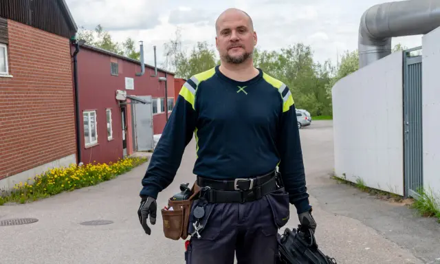 Man med verktygsbälte och väska redo för termografering el. i industriområde.