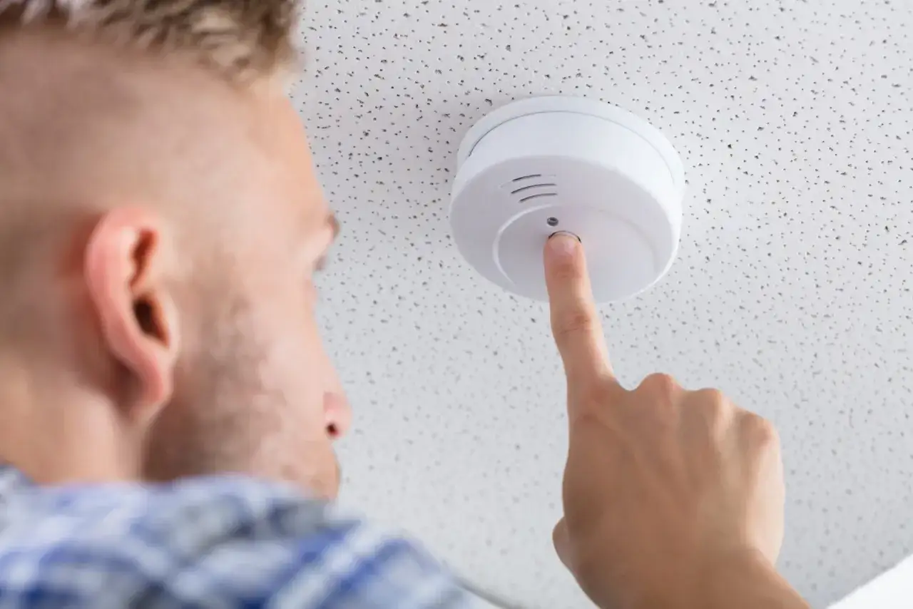 Man testar brandvarnare i sin bostadsrätt för att säkerställa trygghet.