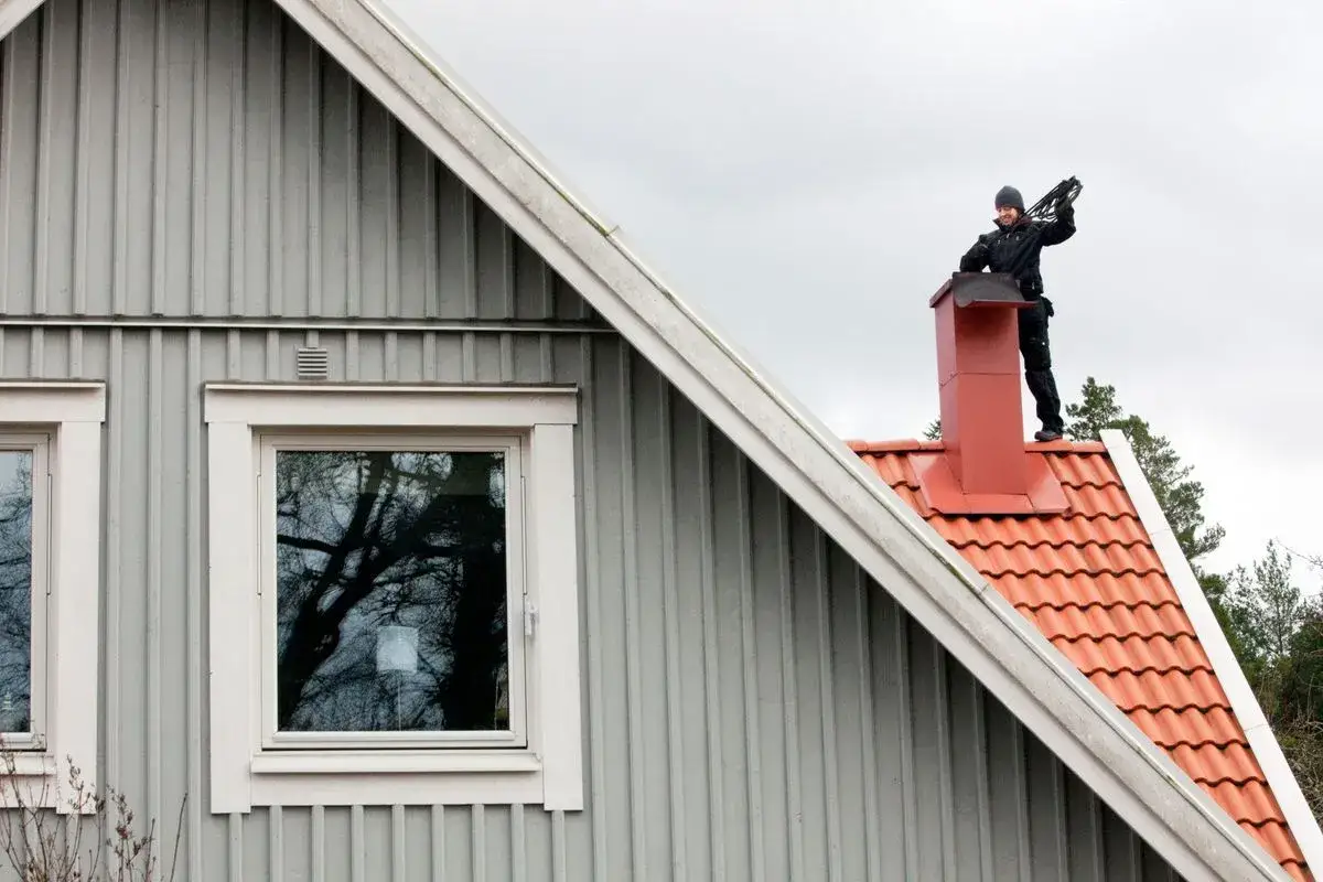 Sotare på taket förbereder sig för sotning. Hur ofta sotning behövs beror på eldstadens användning.
