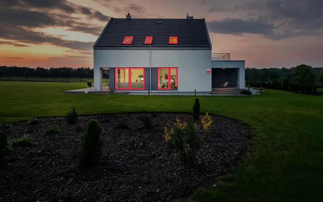 Ett modernt hus med r&ouml;da neonramar runt f&ouml;nster och takf&ouml;nster. Larmet g&aring;r, polisen &auml;r p&aring; v&auml;g.