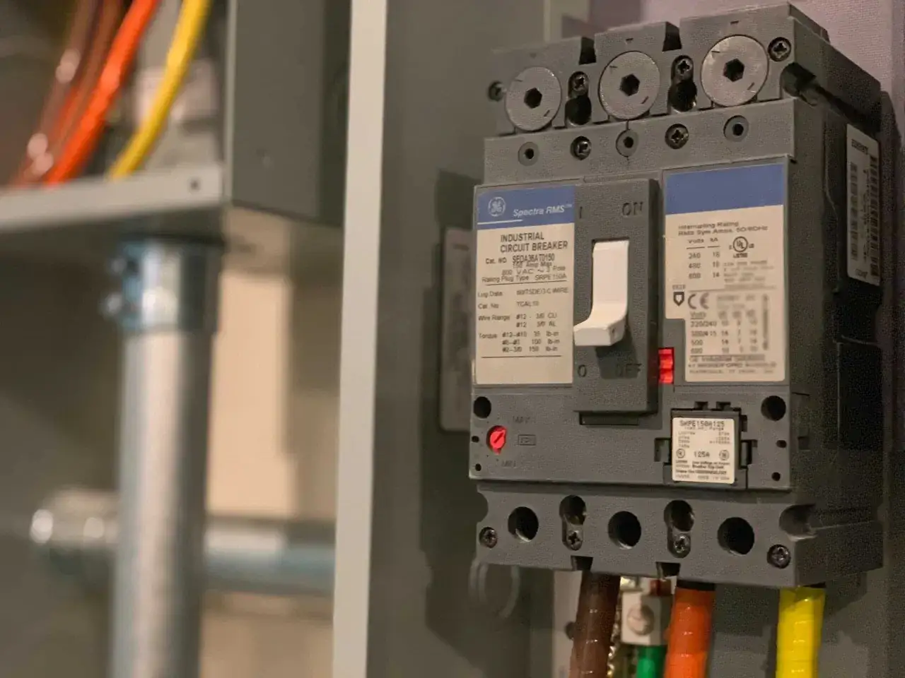En industriell automats&auml;kring fr&aring;n GE Spectra RMS, redo f&ouml;r snabb elinstallation. Kablar i orange, gult och gr&ouml;nt syns i bakgrunden.