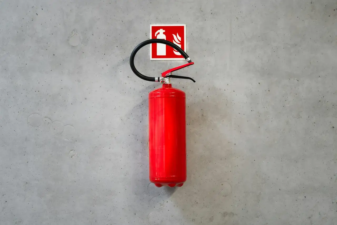 R&ouml;d brandsl&auml;ckare med symbol f&ouml;r brandklass A60 monterad p&aring; en betongv&auml;gg.