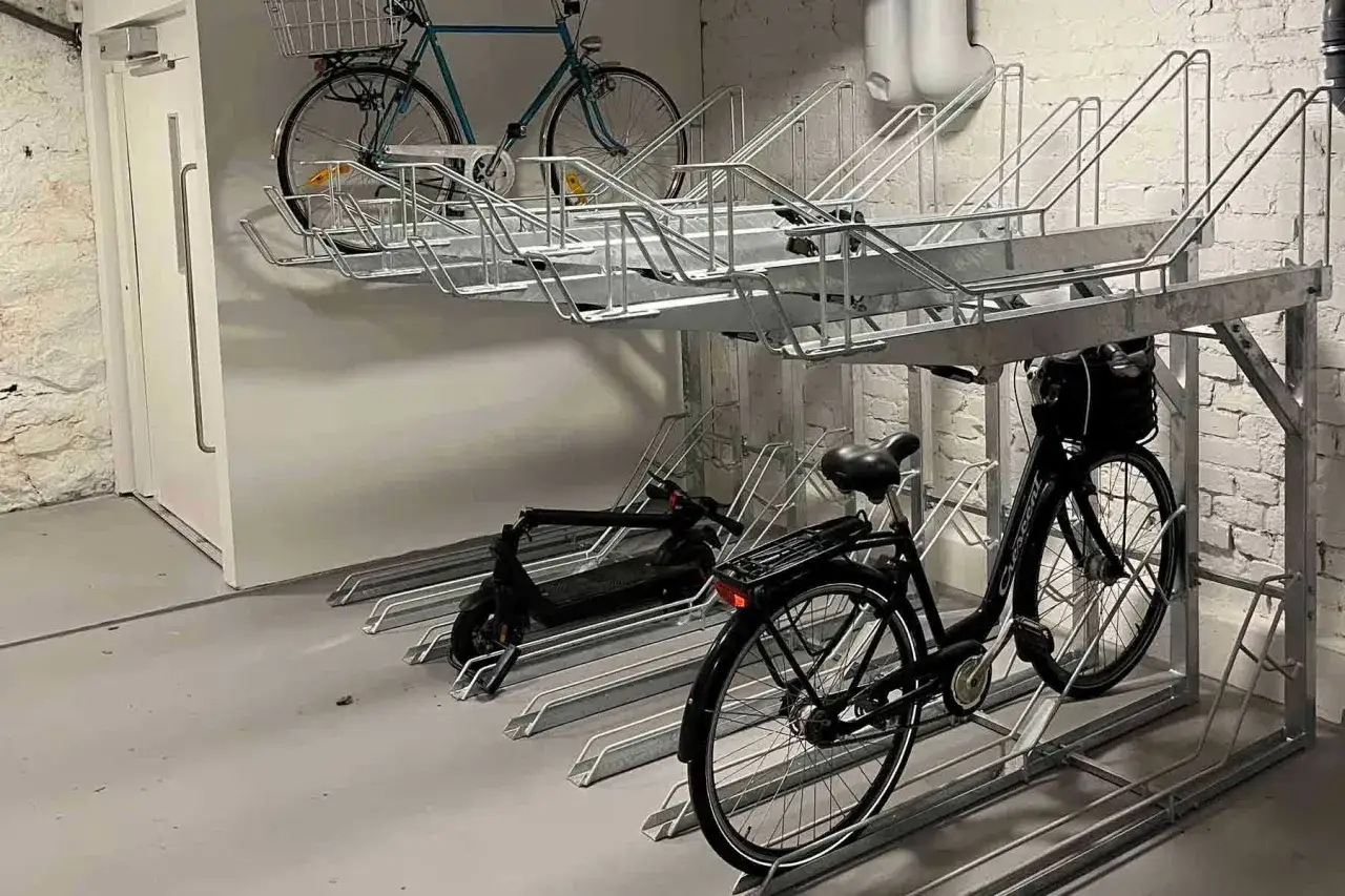 Här kan du ladda elcykeln på jobbet. Parkeringsställ för cyklar och elsparkcyklar i en lokal.