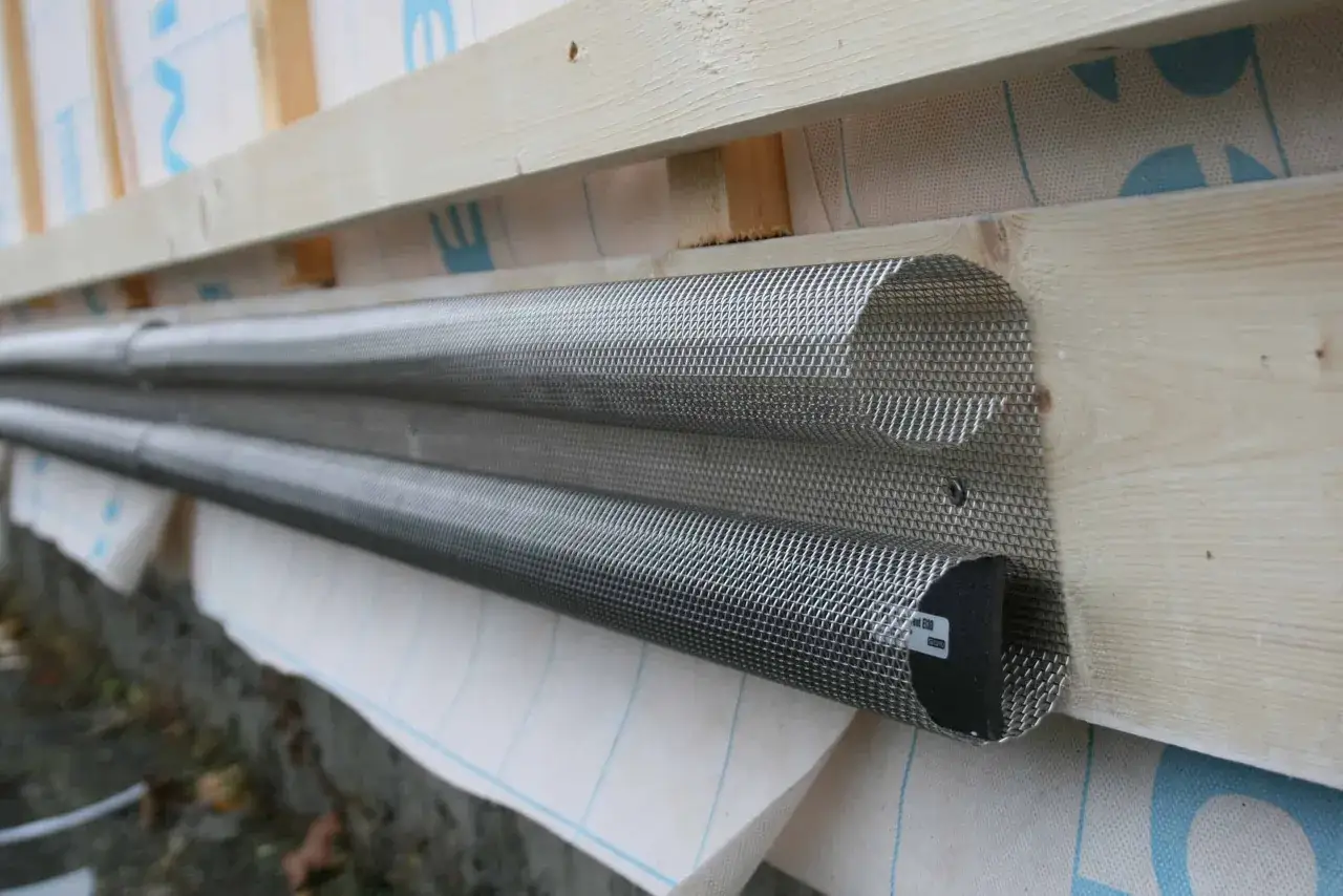 Två rör av metallnät, troligen för ventilation, monterade på träfasad. Dessa kan påverka hur lång tid en brandcell oftast emotstår brand.